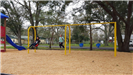 Two kids swinging at the Highland Park Playground