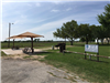 Canopies over picnic tables by Henderson Park sign