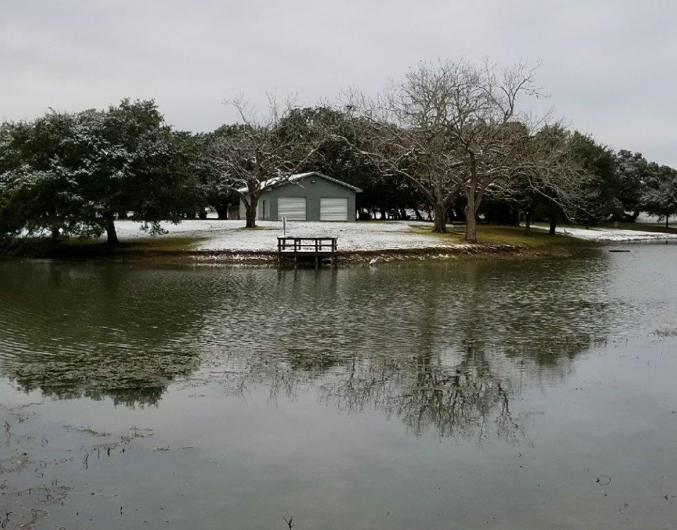 Looking across lake at a small dock and building